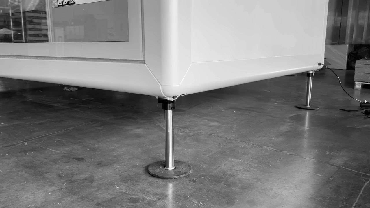Stellfuß unter der Ecke eines weißen KOYA Moduls auf einem Betonboden