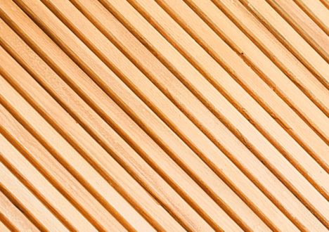 Helle Holzleisten mit schmalen Fugen als Bodenbelag für die Sauna, diagonal verlaufend in der Nahaufnahme