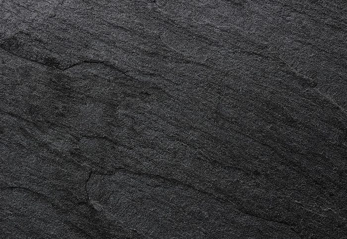 Anthrazitfarbene Keramikfliese mit schieferartig strukturierter Oberfläche, Nahaufnahme von oben