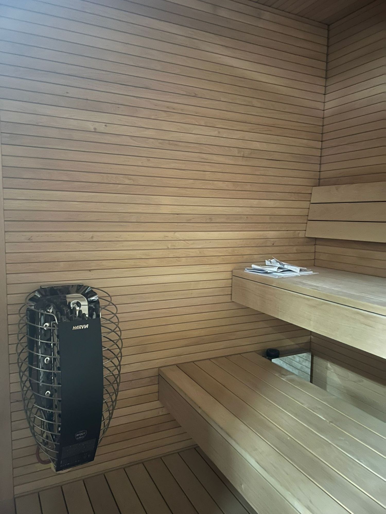 Aufnahme: Saunakabine einer gebauten KOYA Sauna mit Harvia-Ofen und Holzbänken auf zwei Ebenen
