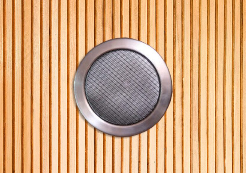 Runder Einbaulautsprecher mit Metallring und feinem Lochgitter in einer Wand aus hellen Holzleisten