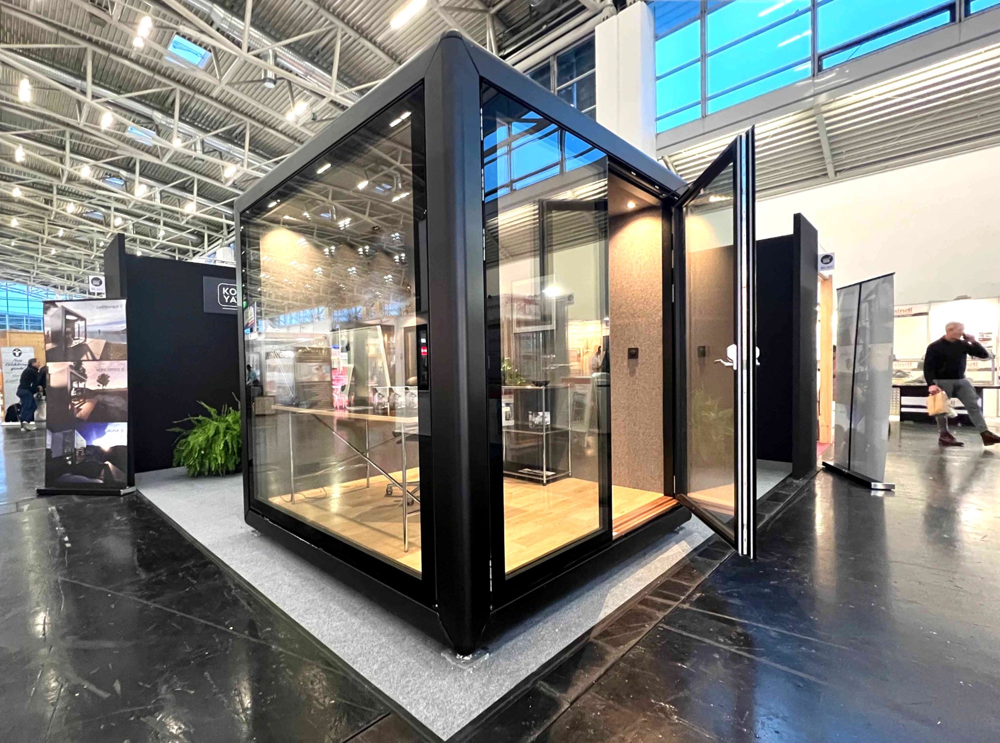 KOYA Cube mit geöffneter Glastür auf einem Messestand